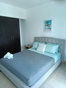 a bedroom with a large bed with blue sheets at Villas de Playa Blanca, Rooftop Vista al Mar in Río Hato