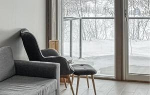 ein Wohnzimmer mit einem Sofa, Stühlen und einem Fenster in der Unterkunft 2 Bedroom Nice Apartment In Geilo in Geilo