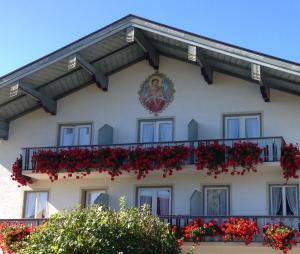 um edifício com flores vermelhas na varanda em Beim Haasen em Grabenstätt