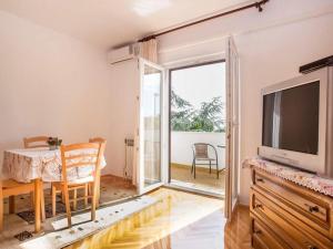 een woonkamer met een tv en een tafel en een eetkamer bij Apartments with a parking space Rovinj - 22527 in Rovinj