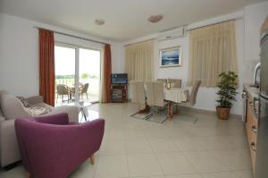 - un salon avec une table et une salle à manger dans l'établissement Apartments and rooms with parking space Trogir - 22531, à Trogir