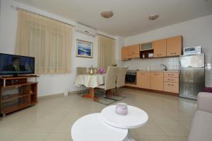 Il comprend un salon avec une table et une cuisine. dans l'établissement Apartments and rooms with parking space Trogir - 22531, à Trogir