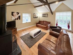 a living room with a couch and a tv at 4 Murton Whitehouse Steading in East Ord