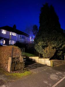a house with a tree in front of it at night at A Home from Home in Redditch near town centre in Redditch