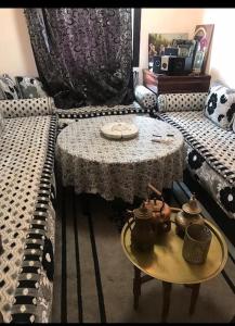 una habitación con dos sofás y una mesa con teteras. en Appartement Marrakech, en Marrakech