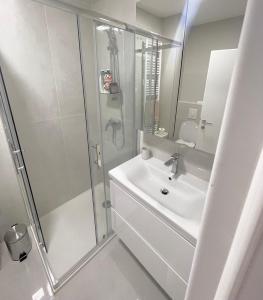 bagno bianco con doccia e lavandino di Apartments with a parking space Zagreb - 22577 a Rakitje