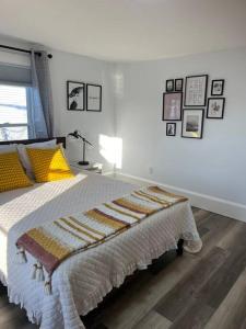 a bedroom with a bed and a lamp and pictures on the wall at Charming 3BR, 1BA Near Heart of Boston! in Watertown
