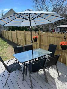 a table and chairs with an umbrella on a deck at Charming 3BR, 1BA Near Heart of Boston! in Watertown