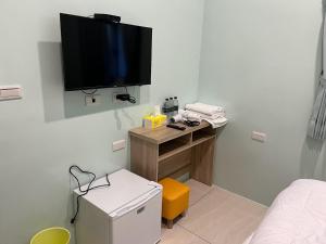 a room with a small desk with a television on the wall at Sky south in Xiaoliuqiu
