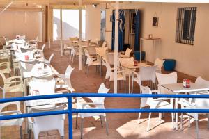 ein Restaurant mit weißen Tischen und Stühlen in der Unterkunft New Premium Apartment - Free Parking & Pools in La Algaba