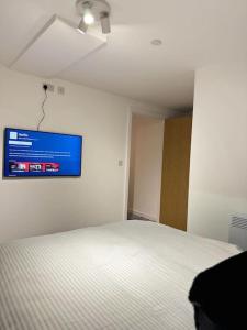a bedroom with a bed with a tv on the wall at Stylish Central Escape in Sheffield