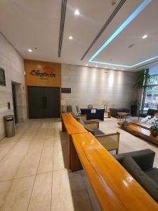 a lobby with a waiting room with tables and chairs at Suite Queen Deluxe BH in Belo Horizonte