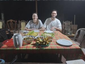 Ein Mann und eine Frau sitzen an einem Tisch mit Essen in der Unterkunft Gimanhala Cottage & Cookary Class in Anuradhapura