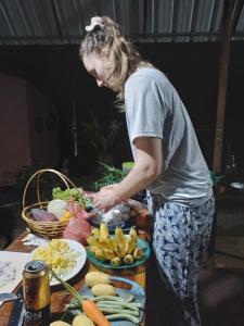 a woman standing in front of a table with vegetables at Gimanhala Cottage & Cookary Class in Anuradhapura