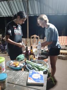 zwei Frauen stehen neben einem Tisch mit Essen in der Unterkunft Gimanhala Cottage & Cookary Class in Anuradhapura