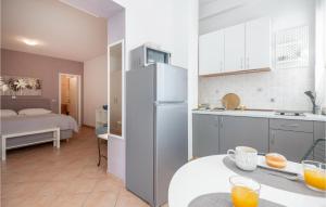 eine Küche mit einem Kühlschrank und ein Zimmer mit einem Bett in der Unterkunft Nice Apartment In Baska Voda With Kitchen in Baška Voda