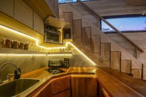 a kitchen with wooden counters and a sink and a window at Cabin VNV in Nosara