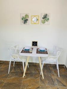 Apartaestudio Turbaco في Turbaco: طاولة بيضاء و كرسيين في الغرفة