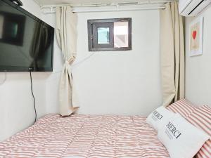 ein kleines Schlafzimmer mit einem Bett und einem TV in der Unterkunft 8 Hotel in Seoul