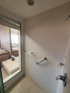 a bathroom with a shower with a sink and a mirror at Suite Queen Deluxe BH in Belo Horizonte