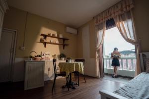 a woman standing in a kitchen with a window at Hue Memories homestay 2 in Hue