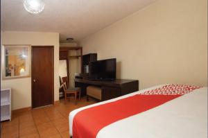 um quarto com uma cama e uma secretária com uma televisão em Hacienda Corteza em Rosarito