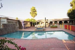 a swimming pool in a courtyard with a building at Hacienda Corteza in Rosarito