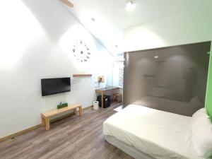 a bedroom with a bed and a flat screen tv at Liuqiu Guihua Homestay in Xiaoliuqiu