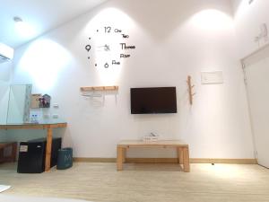a white wall with a clock on a wall at Liuqiu Guihua Homestay in Xiaoliuqiu +14 photos