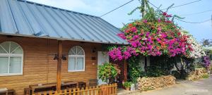 a house with flowers on the side of it at Liuqiu Guihua Homestay in Xiaoliuqiu