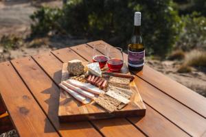 una mesa de madera con 2 copas de vino y una botella en Tiny Rupetta en Currie