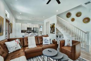 a living room with brown leather furniture and a staircase at Lake Hm Hill Mountain View-BOAT Rental Available! in Canyon Lake