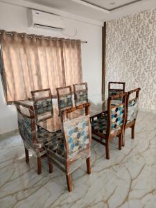 a dining room with a table and four chairs at Manidweepa farm house in Venkatāpur