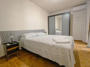Un dormitorio con una cama grande y un espejo. en Apartamento Smart Centro MC53, en Maringá
