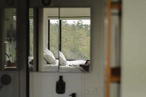 a reflection of a person laying on a bed in a mirror at Tiny Nancy in Bellingen +13 photos