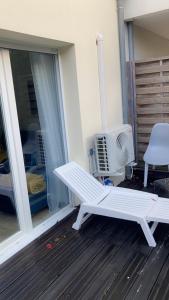 um banco branco sentado no alpendre de uma casa em Mi appartement mi maison em Guyancourt