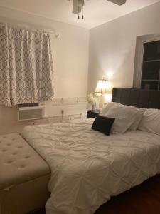 Wonderful Gables bedroom في ميامي: سرير أبيض كبير في غرفة نوم مع نافذة