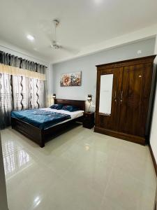 a bedroom with a bed and a wooden cabinet at Matheera holiday home in Jaffna