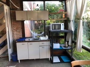 a kitchen with a sink and a microwave at Hotel Gaudí in Punta del Este