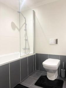 a white bathroom with a shower and a toilet at Manchester City Center Apartment in Manchester