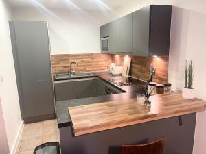 a kitchen with a wooden counter top and a sink at Manchester City Center Apartment in Manchester