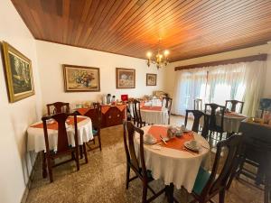 a dining room with tables and chairs in a room at Pousada Recanto Paulista in Campos do Jordão