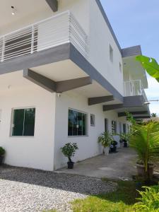 un edificio blanco con una escalera azul en Moriá Flats en Ubatuba