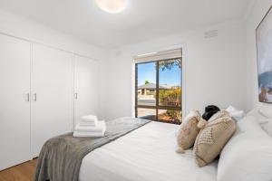 ein weißes Schlafzimmer mit einem großen weißen Bett mit Kissen in der Unterkunft Wilson Executive Apartments in Thomson