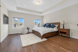 a white bedroom with a bed and a desk and window at Executive 5BR-4BATH Detached Bramp/Miss Border in Brampton