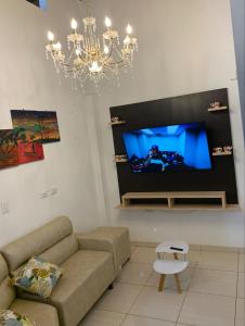 a living room with a couch and a flat screen tv at ApartaHostal Quintanilla in Villanueva