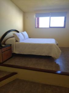 1 dormitorio con 1 cama grande y ventana en La Casona del Lago en Balneario Ipora