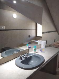 uma casa de banho com 2 lavatórios e um espelho grande em La Casona del Lago em Balneario Ipora
