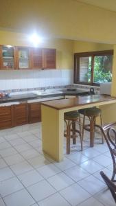uma cozinha com uma mesa e algumas cadeiras em La Casona del Lago em Balneario Ipora