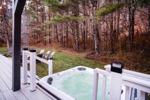 uma banheira de hidromassagem no alpendre de uma casa em Prattvilla -Catskill -Mountain Escape 5 BR ,3 bath with Hot tub em Prattsville